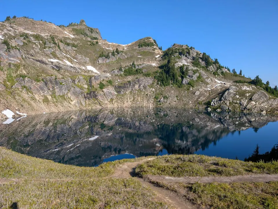 Petit lac de montagne au pied d'une crête rocheuse