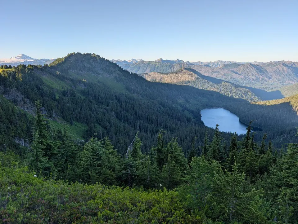 Lac bleu entouré d'une forêt dense et de crêtes montagneuses