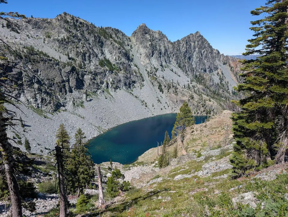 Lac bleu sombre au pied d'un cirque rocheux escarpé