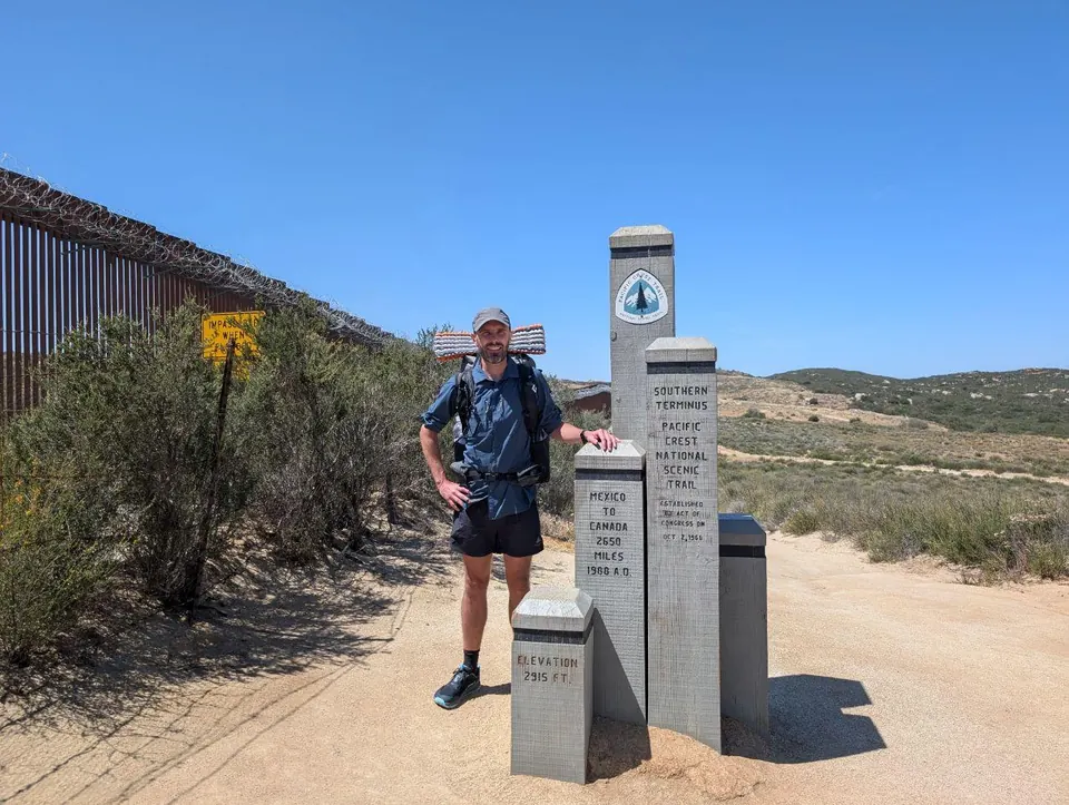 Randonneur debout auprès du monument marquant le terminus sud du Pacific Crest Trail