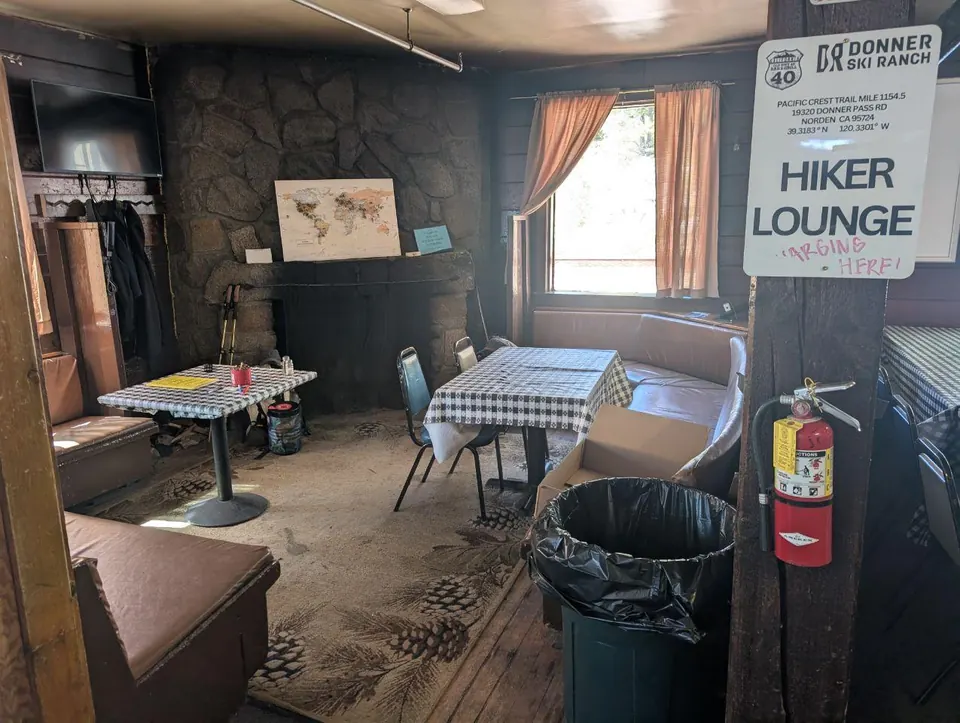 Salle rustique aménagée en hiker lounge avec tables et bancs
