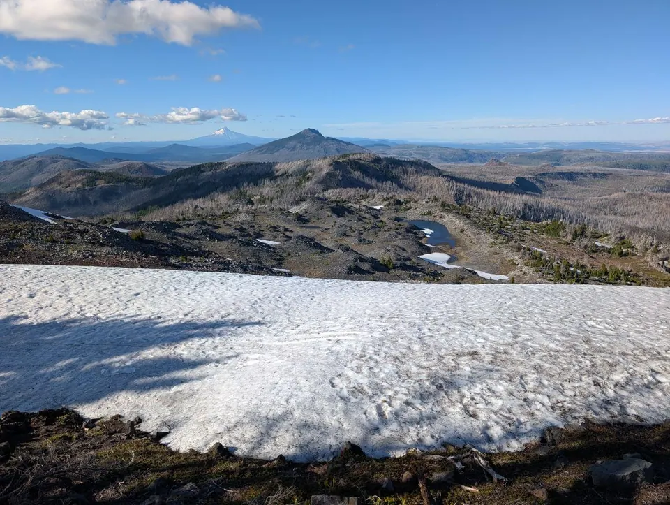 Névé au premier plan et sommets volcaniques sous un ciel dégagé