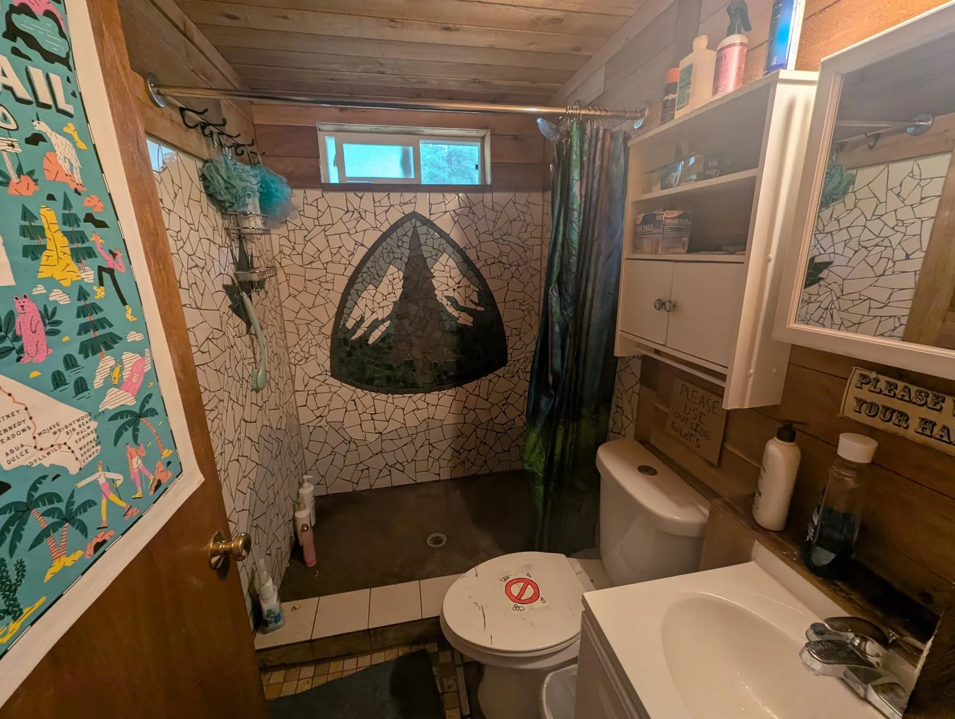 Petite salle de bains en bois avec douche, lavabo et toilettes