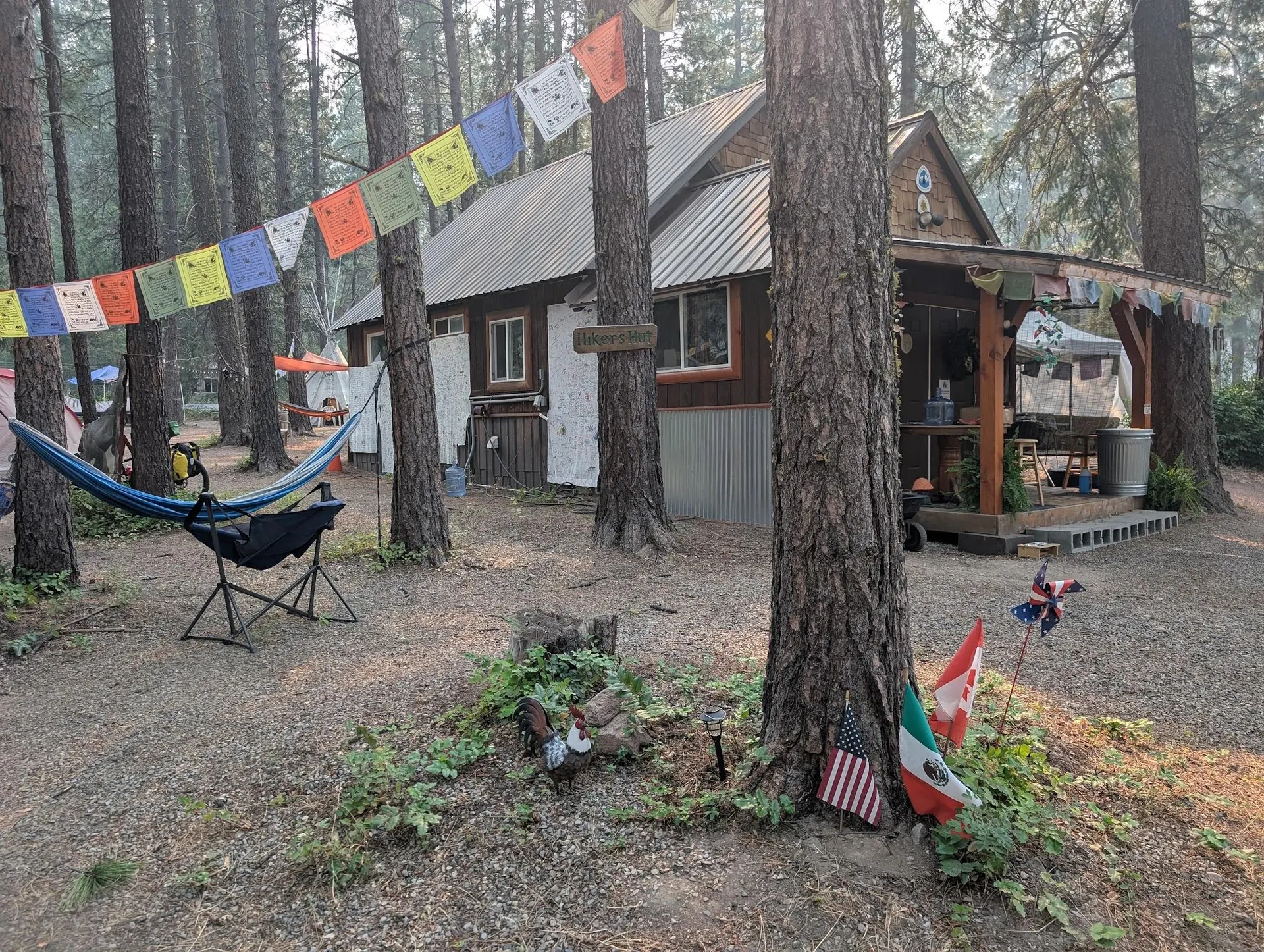 Hamac et chaise installés devant une cabane décorée de fanions