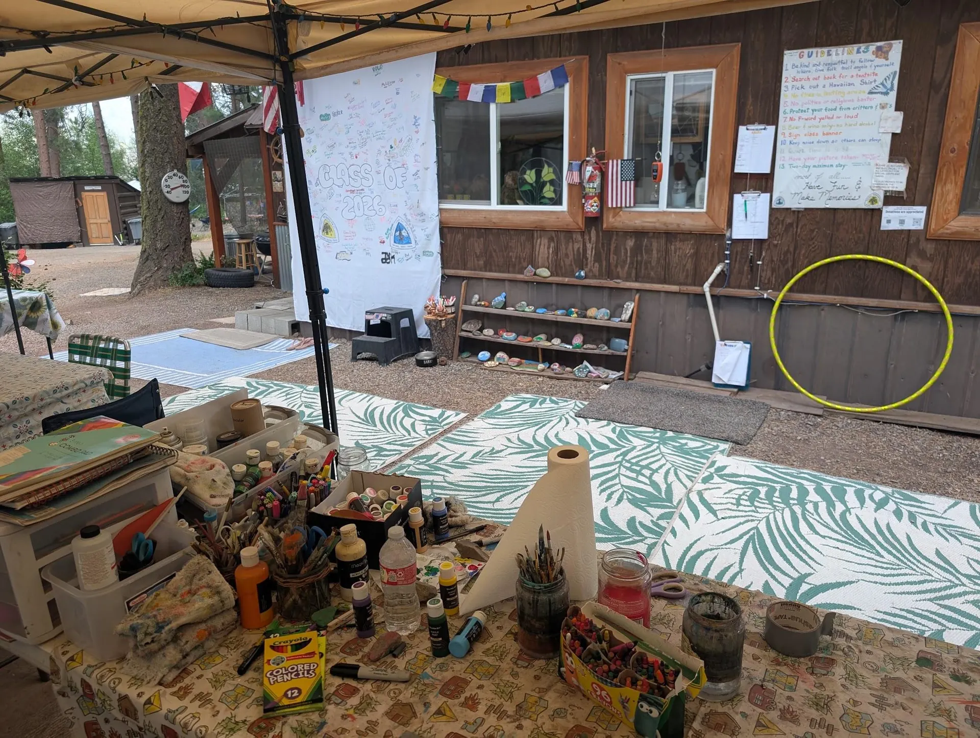 Table de ravitaillement chargée de boissons et nourriture devant une cabane