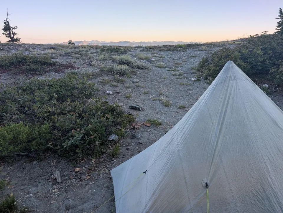 Tente légère dressée sur un plateau rocheux au crépuscule