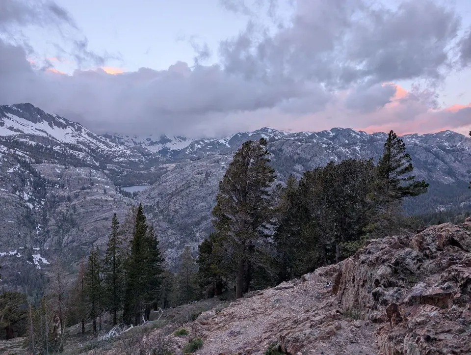 Crêtes enneigées sous des nuages teintés de rose au crépuscule