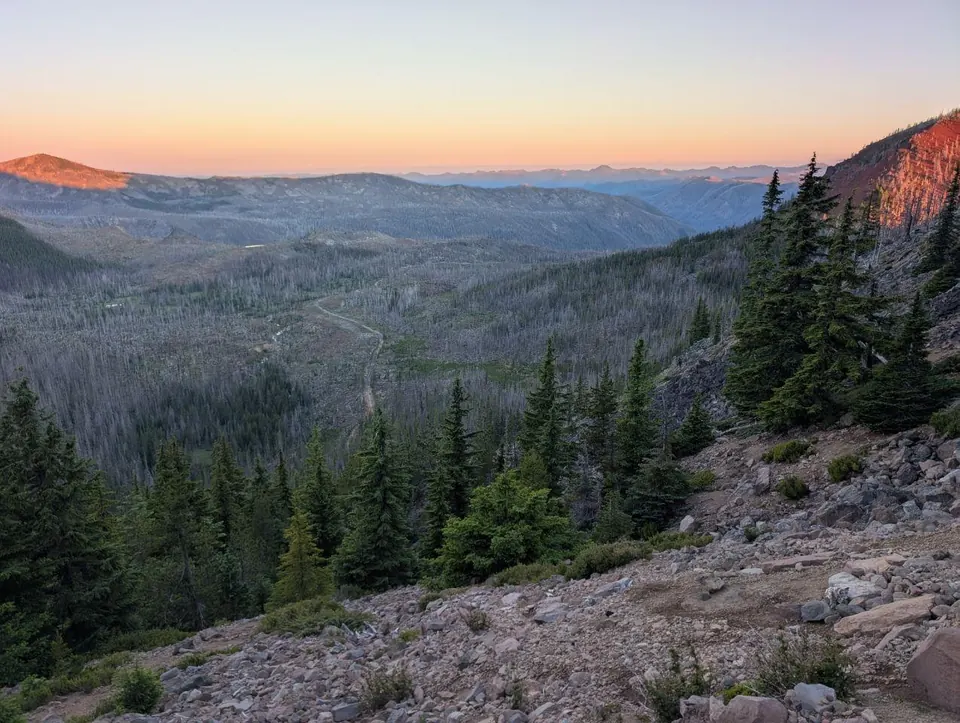 Vallée boisée éclairée par les dernières lueurs du soleil