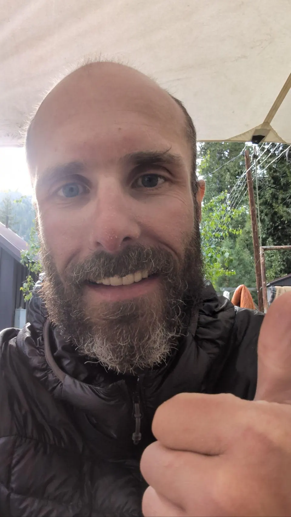 Randonneur barbu souriant et levant le pouce