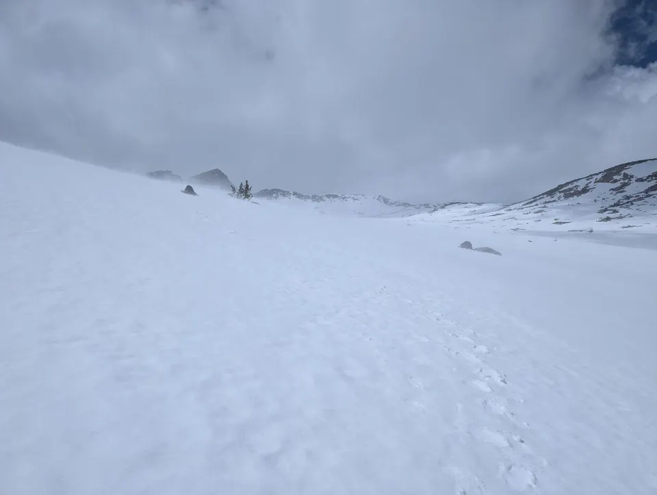 Pente entièrement enneigée disparaissant dans le brouillard