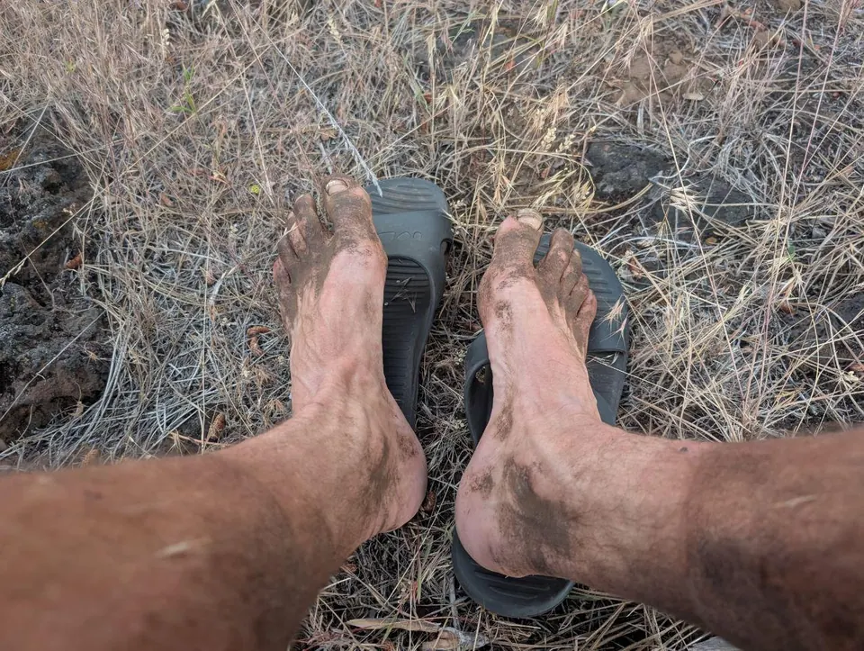 Pieds poussiéreux reposant à côté d'une sandale