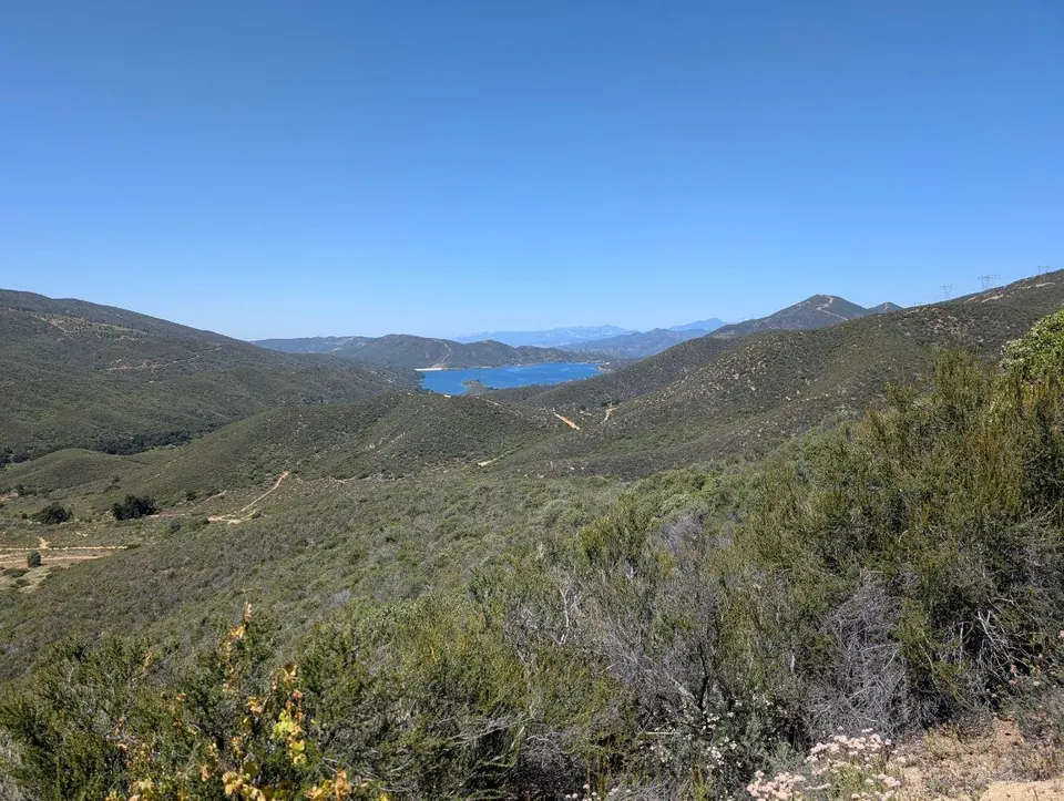 Réservoir bleu au fond d'une vallée couverte de broussailles