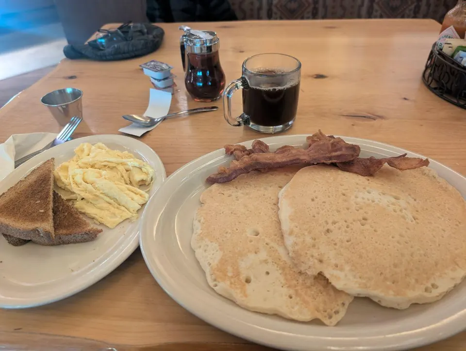 Assiette de pancakes avec œufs, bacon et café