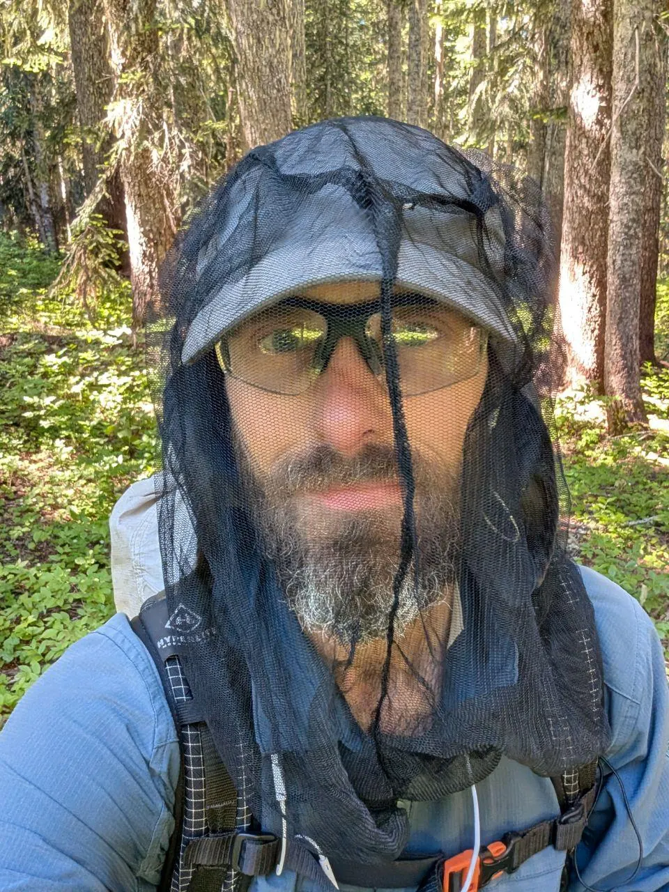 Randonneur trempé sous une capuche et des lunettes