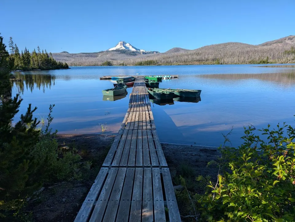 Pontons étroits et embarcations sur un lac face à un sommet enneigé