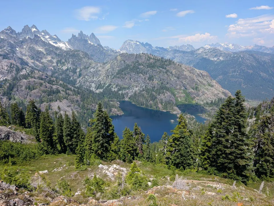 Lac alpin entouré de sommets escarpés et de sapins