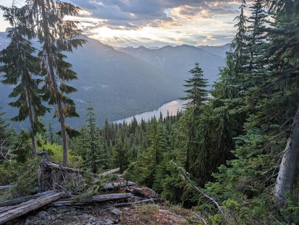 Vallée boisée et lac lointain dans la lumière du soir