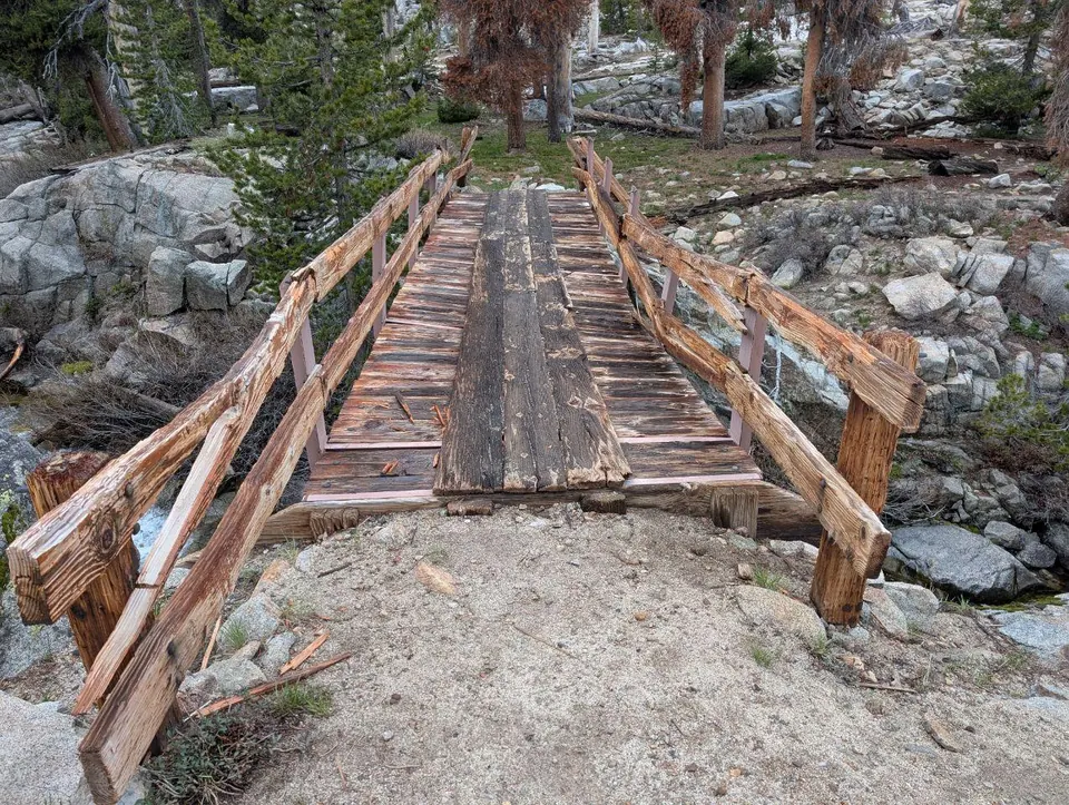 Passerelle rustique en bois franchissant un torrent