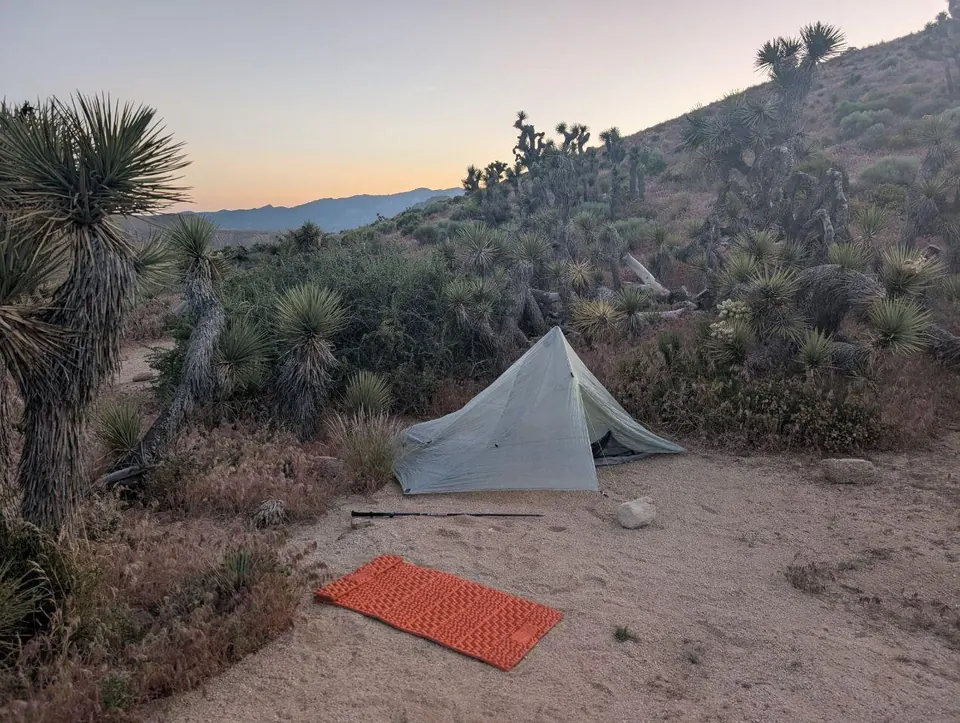 Tente légère installée dans le désert au crépuscule