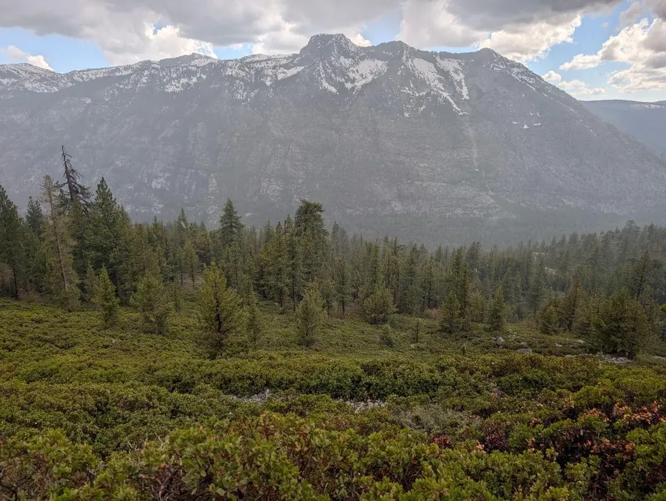 Vallée montagneuse sous un ciel chargé de nuages