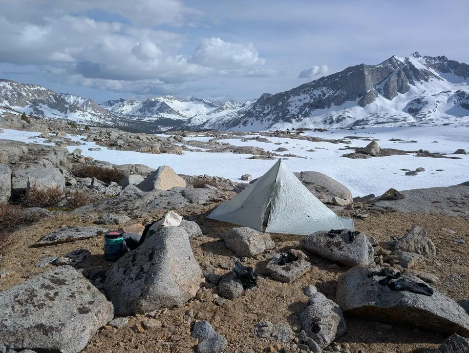 Tente dressée parmi les rochers dans un paysage enneigé