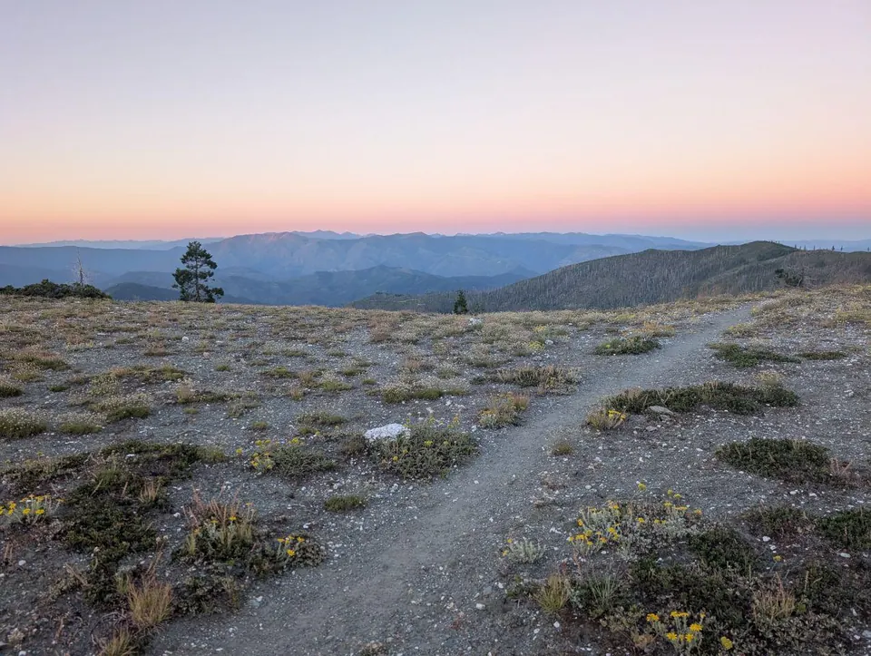 Sentier de crête au crépuscule sous un ciel rose