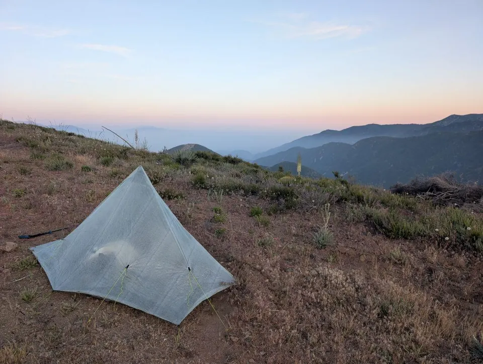 Tente légère sur une crête herbeuse au crépuscule