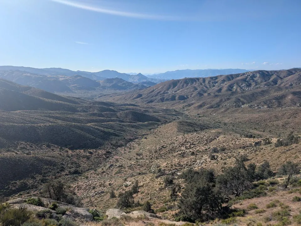 Collines arides s'étendant jusqu'aux montagnes lointaines