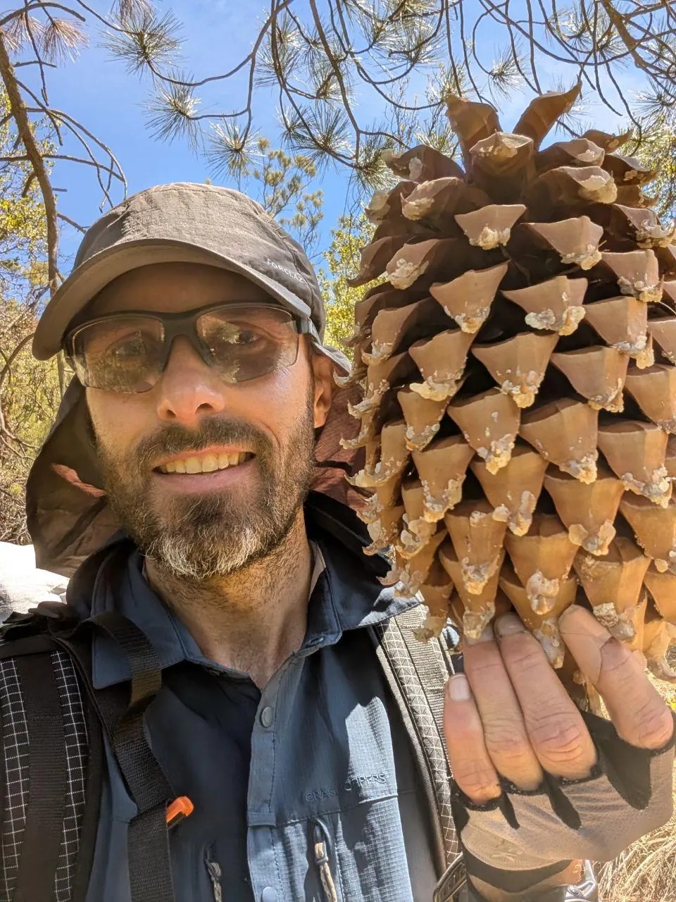 Randonneur souriant avec un fagot de bois attaché au sac