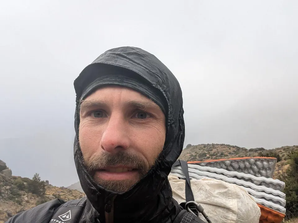 Randonneur encapuchonné sous la pluie et le brouillard
