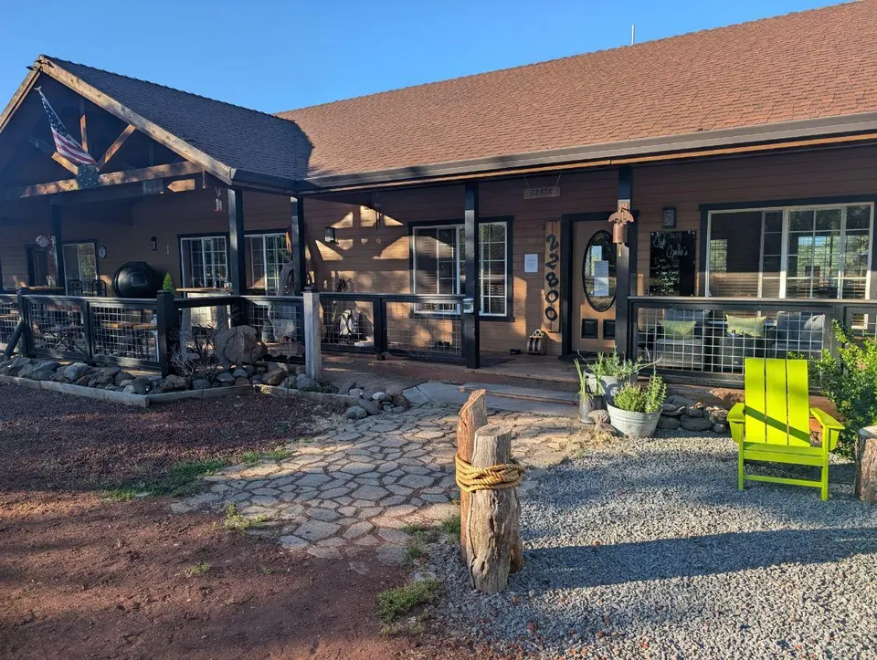 Façade en bois d'un hébergement avec une chaise verte