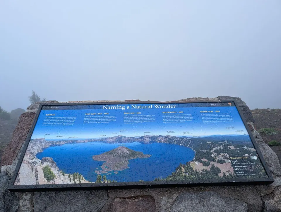 Panneau d'information sur un lac volcanique masqué par le brouillard