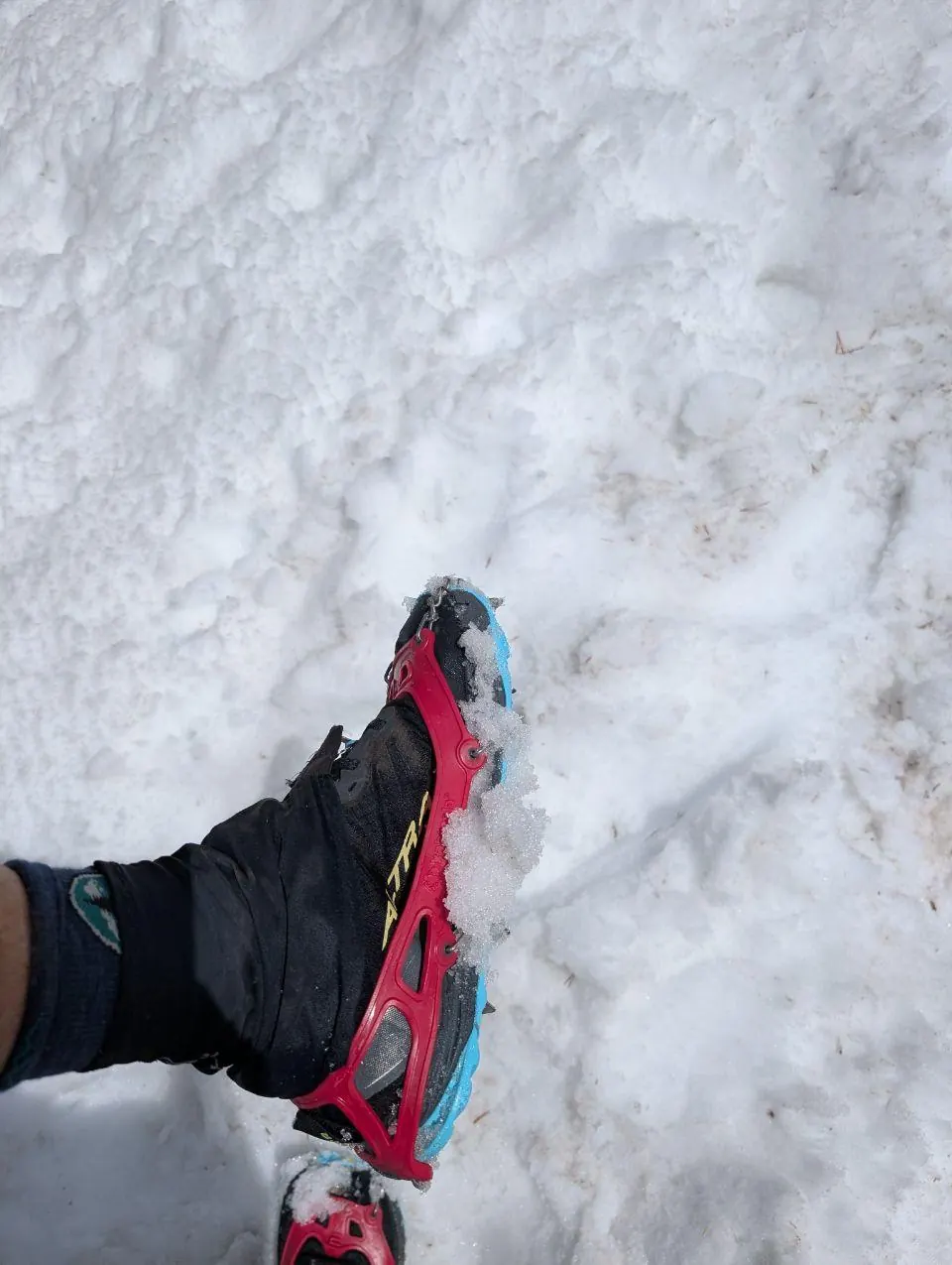 Chaussure rouge équipée d'une pointe sur la neige
