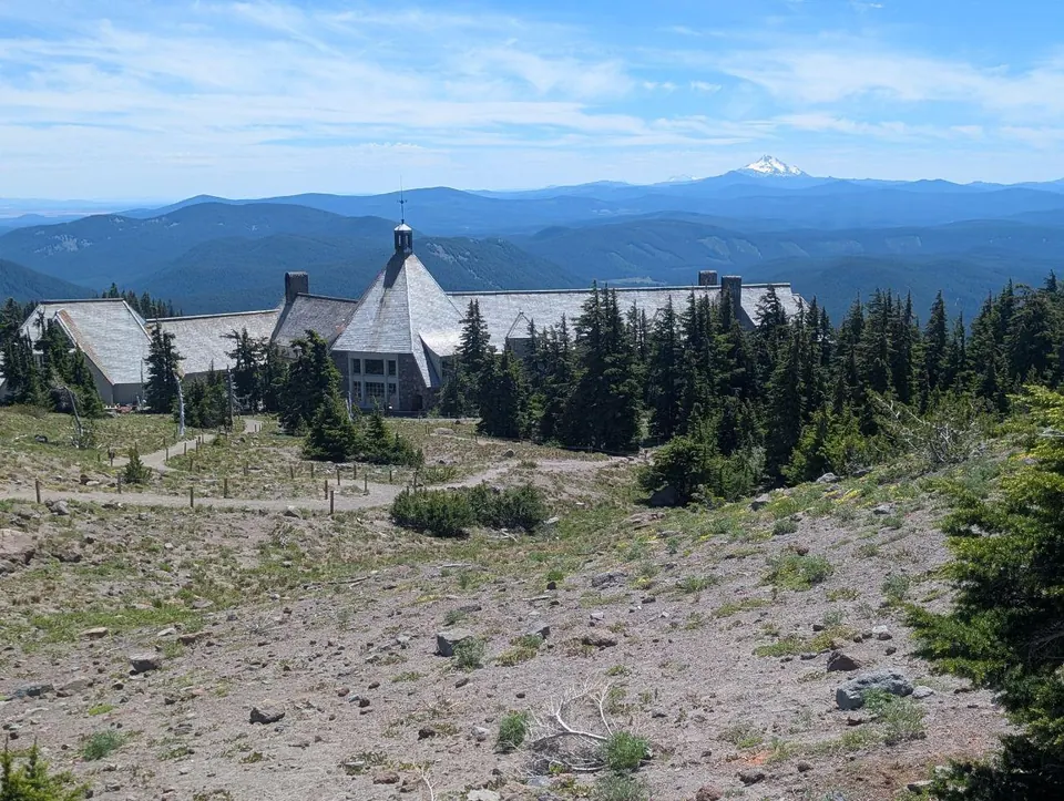 Refuge de montagne dominant une succession de crêtes boisées